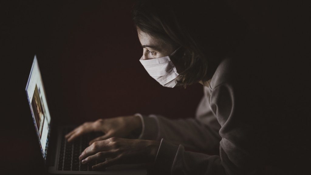 Laptop user wearing mask