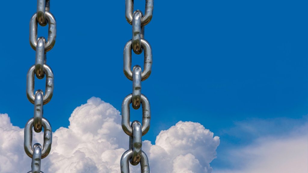 Metal chains in front of sky with white clouds